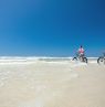 Mutter und Sohn fahren Fahrrad am Strand, New Smyrna Beach, Florida - Credit: New Smyrna Beach