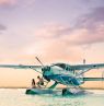 Paar und Wasserflugzeug bei Sonnenuntergang, Deluxe, Themenreisen, BAH Credit: The Bahamas Ministry of Tourism & Aviation